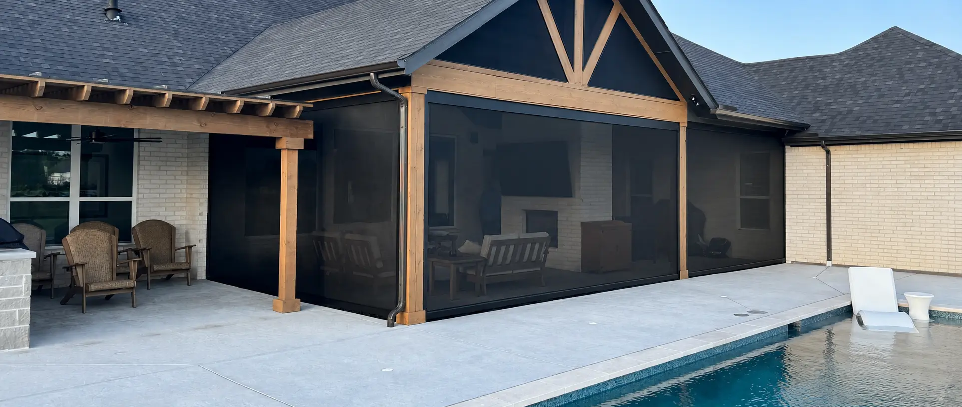 Finished timber-framed pool patio enclosed with multiple dark motorized screens.